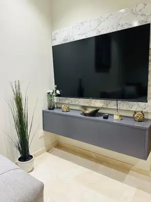 a living room with a large television on a wall at Studio Al Amir 12 CFC à 2mn in Casablanca