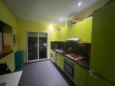 a kitchen with yellow and green cabinets and a window at Les perles de tamaris in Dar Mohammed Ould Haj Jilali