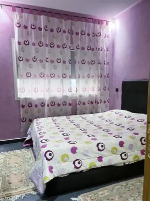 a bedroom with a bed and a curtain with polka dots at Les perles de tamaris in Dar Mohammed Ould Haj Jilali