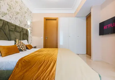 a bedroom with a large bed with a yellow blanket at Les Tours Végétales, Casablanca Finance City in Casablanca