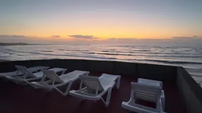 a group of chairs sitting on the beach at sunset at surf trip in Kasba Bou Hamira