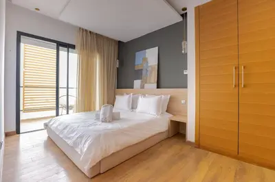 a bedroom with a bed with white sheets and a window at Luxurious and modern 2BR with Stunning View in Beni Brour