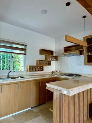 a kitchen with wooden cabinets and a counter top at Casa Jnane Jawhara Skhirat in Rabat