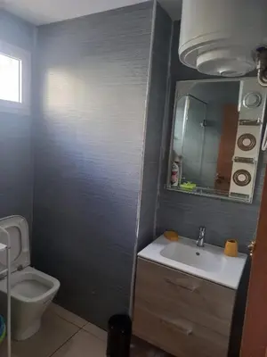 a bathroom with a sink and a toilet and a mirror at vague bleue de bouznika in Bouznika