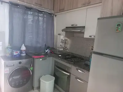 a kitchen with a refrigerator and a washing machine at vague bleue de bouznika in Bouznika