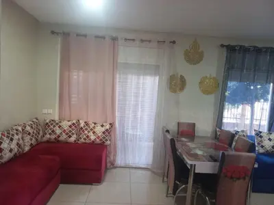 a living room with a red couch and a table at vague bleue de bouznika in Bouznika