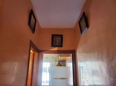 a room with orange walls and a mirror and a refrigerator at à 10 minutes du grand mall d'Afrique, WiFi Netflix 1ère étage in Oulad Hamida