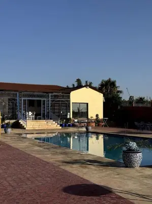 a swimming pool in front of a house at Jnane Jawhara Skhirat studio in Skhirat