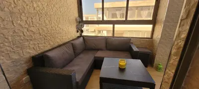 a living room with a couch and a table at Appart à Malaga Beach Mansouria in Mansouria