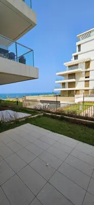 a sidewalk in front of a building and a beach at le carrousel Rabat Océan in Kouas
