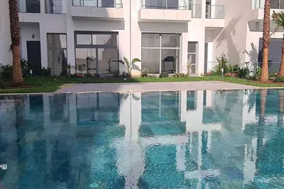 a swimming pool in front of a building at Chic & Charme Studio Près de l'aéroport in Nouaceur