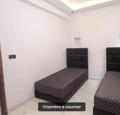 two beds in a room with a sign that says charisma controller at Luxury apartment in Casablanca