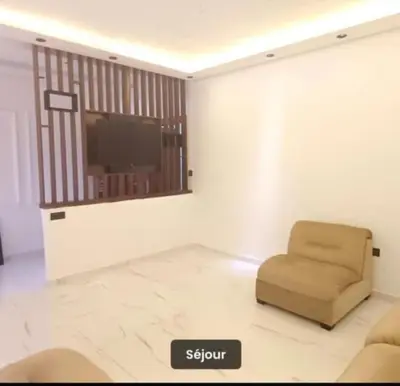 a living room with a chair and a flat screen tv at Luxury apartment in Casablanca