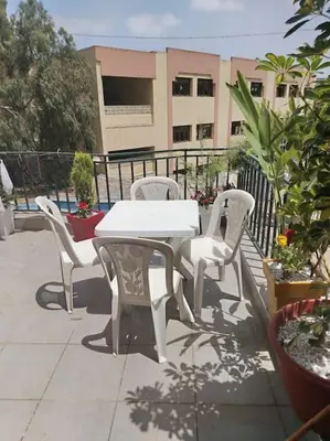 a white table and chairs on a patio at Joli Apparemment et calme in Casablanca