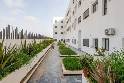 a courtyard of a building with potted plants at Residence GYA Beach - Luxe Moderne et Confort à Harhoura accès plage in Temara