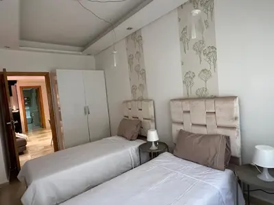 a bedroom with two beds and a hallway at Ricks appartement in Casablanca