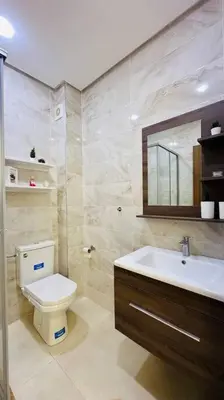 a bathroom with a toilet and a sink and a mirror at Cosy Suite Appart in Kasba Bou Hamira