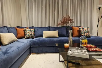 a blue couch in a living room with a table at Emplacement Central & So Stylish Près du Consulat Américain 2 minutes de Twin Center Gauthier Casablanca in Casablanca