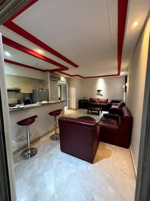 a living room with a couch and a kitchen at Votre chez-vous à Casa, une ambiance cosy garantie in Casablanca