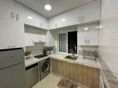 a kitchen with white cabinets and a washer and dryer at Élégance familiale à Skhirate près de la plage et la ville in Skhirat