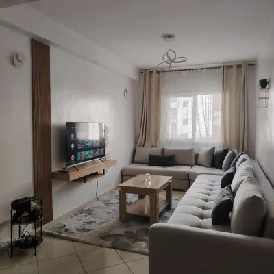 a living room with a couch and a tv at Élégance familiale à Skhirate près de la plage et la ville in Skhirat