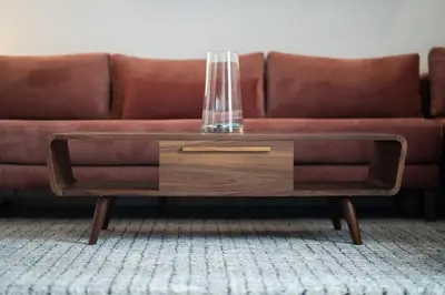 a brown couch with a glass vase on a coffee table at Studio Raffiné en Centre Ville in Casablanca