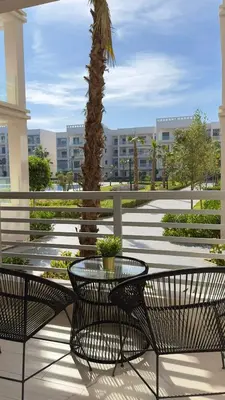 a patio with a table and chairs and a palm tree at Cosy Suite Appart in Bouznika