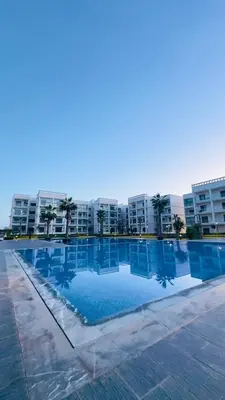 a large swimming pool in front of a building at Cosy Suite Appart in Bouznika