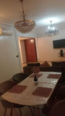 a dining room table with chairs and a chandelier at Appartement à Maarif in Casablanca