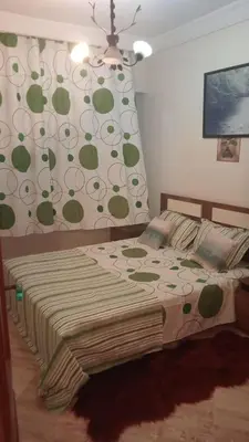 a bedroom with a bed with a green and white wall at Appartement à Maarif in Casablanca