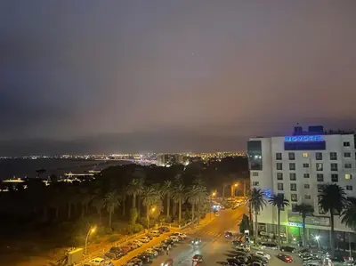 a city at night with cars and a building at Apparemment 300 m de la plage, Parc Mohammedia in Mohammedia