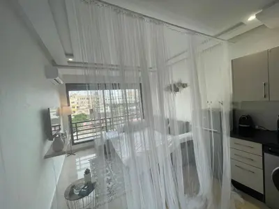 a kitchen with a large window with white curtains at Joli cocon en plein centre a10 min a pieds de la corniche in Casablanca