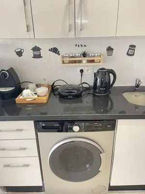 a kitchen with a washing machine and a sink at Joli cocon en plein centre a10 min a pieds de la corniche in Casablanca