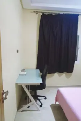 a room with a desk and a window with a table and a bed at appartement calme in Casablanca