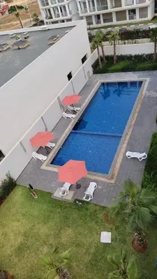 an overhead view of a swimming pool with chairs and umbrellas at Appartement luxueux avec piscine dans une résidence calme in Bouznika