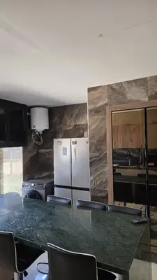 a kitchen with a counter with chairs and a refrigerator at Casablanca marina in Casablanca