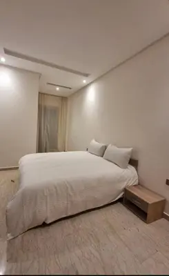 a bedroom with a large white bed and a table at Cosy Aparts, 2BR, downtown, near tramway in Casablanca