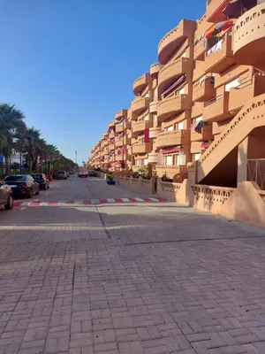 an empty street in front of a large building at Goulmim in Mohammedia