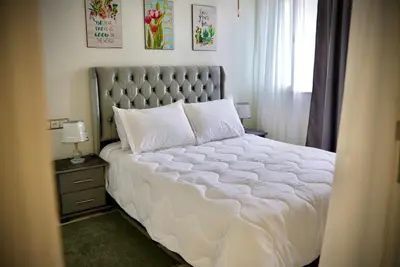 a bedroom with a large white bed and a window at appartement luxe rabat ville in Rabat