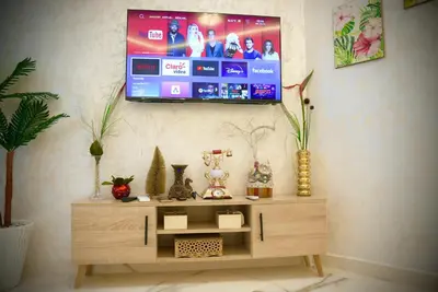 a tv hanging on a wall in a living room at appartement luxe rabat ville in Rabat