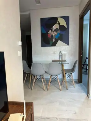 a dining room with a table and chairs and a painting at Stylish 2 bedroom, in the heart of Casablanca in Casablanca