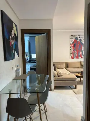 a living room with a glass table and chairs at Stylish 2 bedroom, in the heart of Casablanca in Casablanca