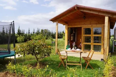 a small cabin with a table and chairs in the yard at Countryside's Tiny House in O Ben Slimane