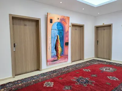 a room with two doors and a painting on the wall at Hôtel Les Remparts in Azemmour