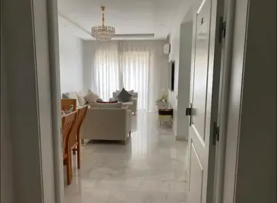 a white living room with a couch and a table at Apparemment Meuble a 5 min de l'aéroport casa in Nouaceur
