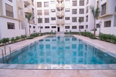 a swimming pool in front of a building at Apparemment Meuble a 5 min de l'aéroport casa in Nouaceur