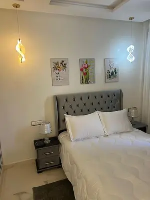 a bedroom with a bed and a table with a lamp at Cozy appartement Rabat in Rabat