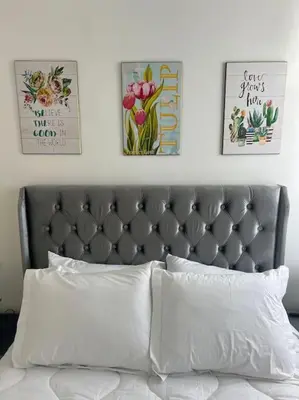 a bed with three pictures on the wall above it at Cozy appartement Rabat in Rabat
