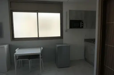 a small kitchen with a table and a window at Les portes de Temara in Temara