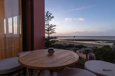 a table in a balcony with a view of the beach at Luxury Suite Mannesmann - Seaview in Mohammedia